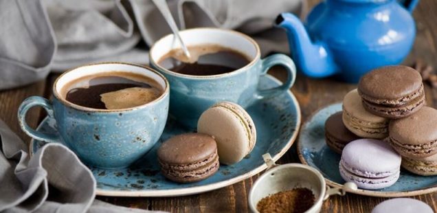 Blue teapot with 2 cups sharing a saucer, cookies, and a crumpled napkin