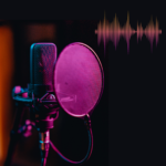Image of a microphone with pink and orange highlights on a black background with a pink and orange sound wave.